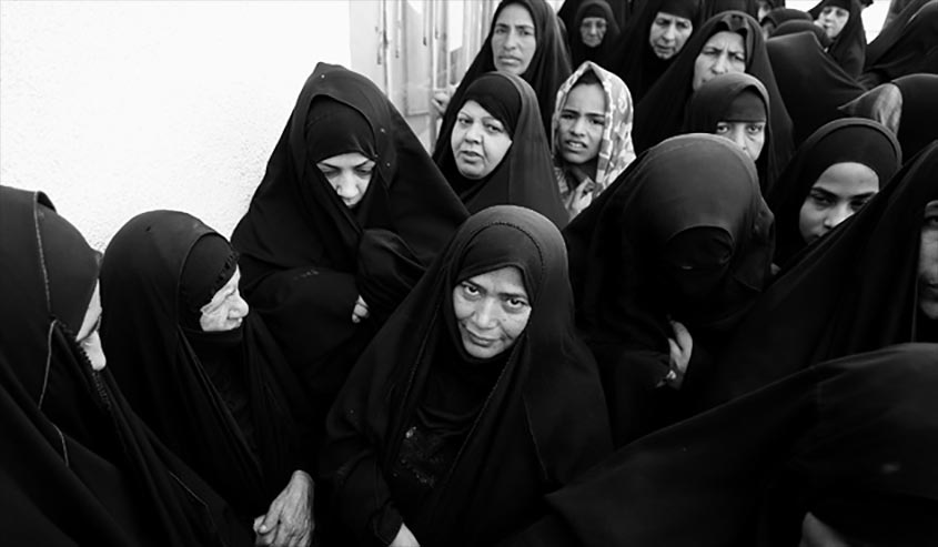 Iraqi widows wait to receive aid